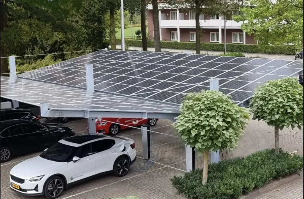Parkeerplaats met een carport vol zonnepanelen bij een bedrijfspand